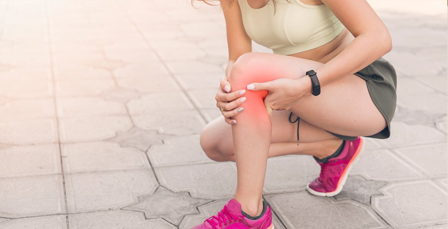 female athlete crouching in pain